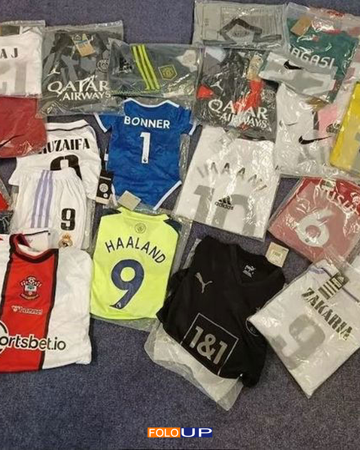 A large collection of counterfeit football shirts in plastic packaging after seizure